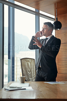 Buy stock photo Shot of a mature businessman talking on his cellphone at work