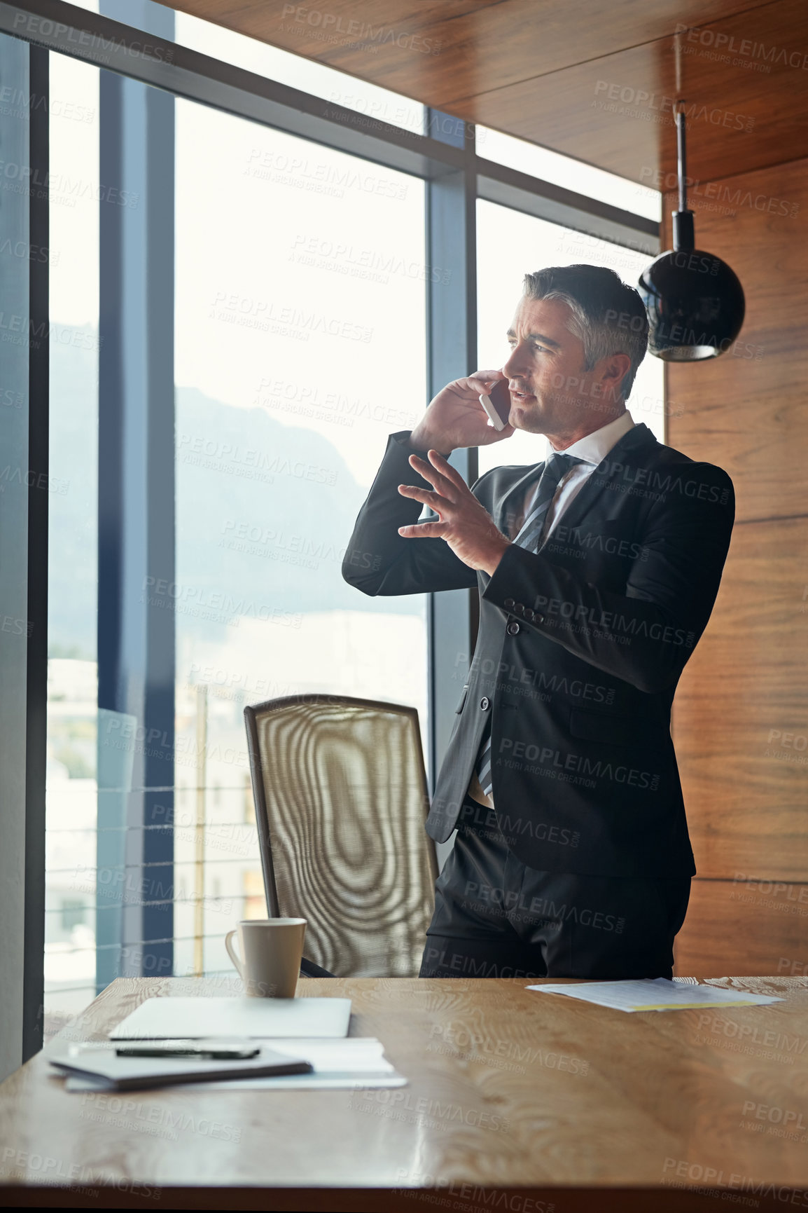 Buy stock photo Shot of a mature businessman talking on his cellphone at work