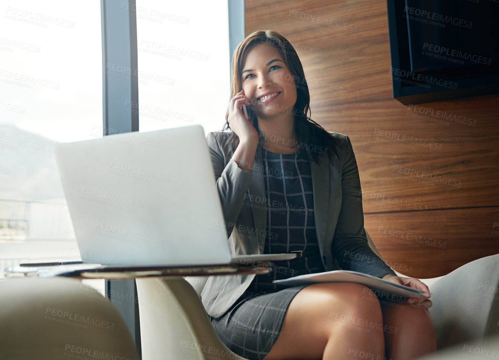 Buy stock photo Cropped shot of a businesswoman using her laptop in the office while answering a phonecall