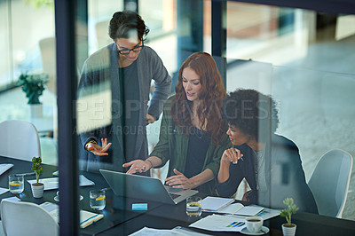Buy stock photo Cropped shot of colleagues working together on a laptop in a modern office