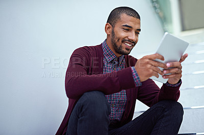 Buy stock photo Cropped shot of a young businessman using a digital tablet on the stairs in a modern office