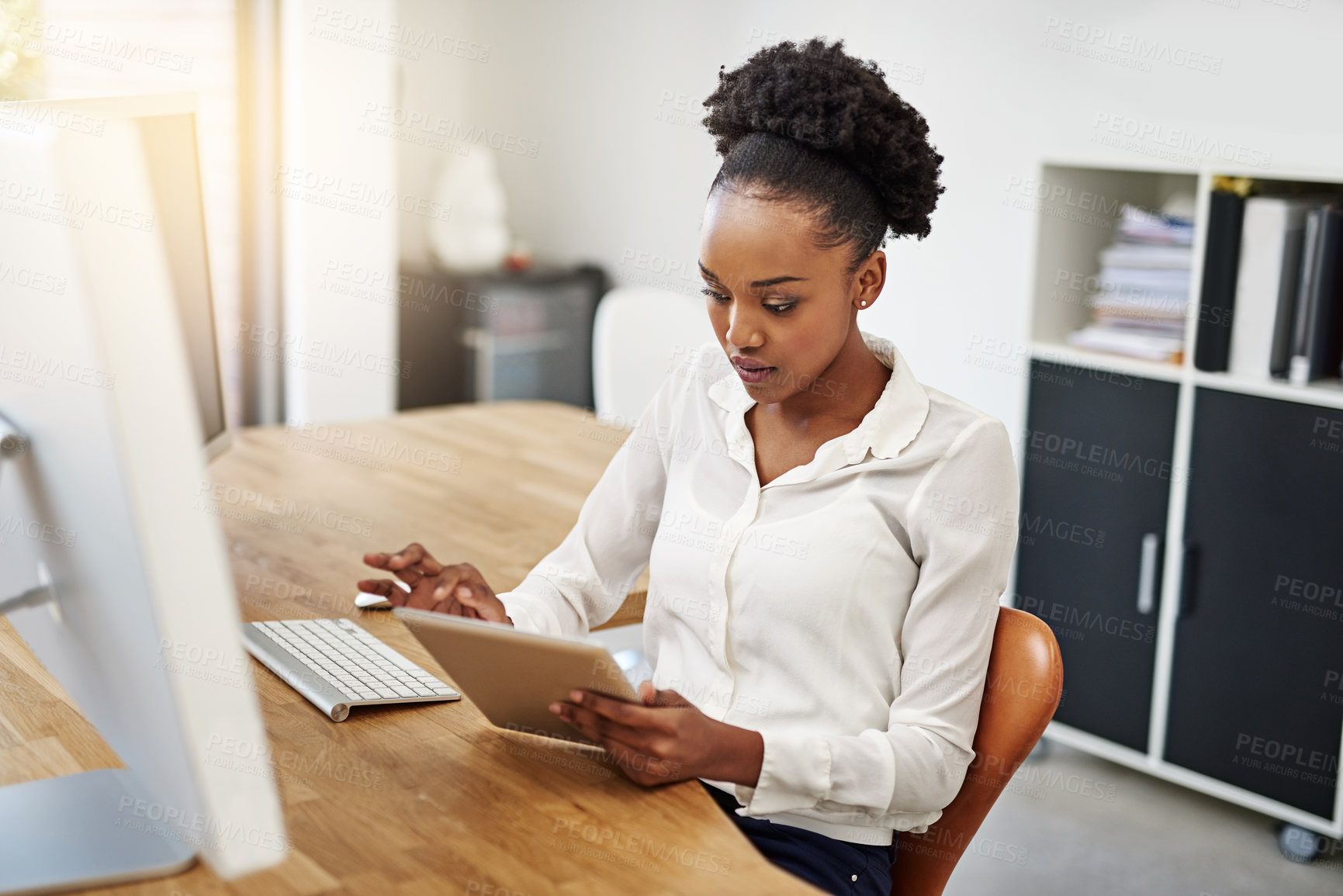 Buy stock photo Shot of a young businesswoman using a digital tablet at work