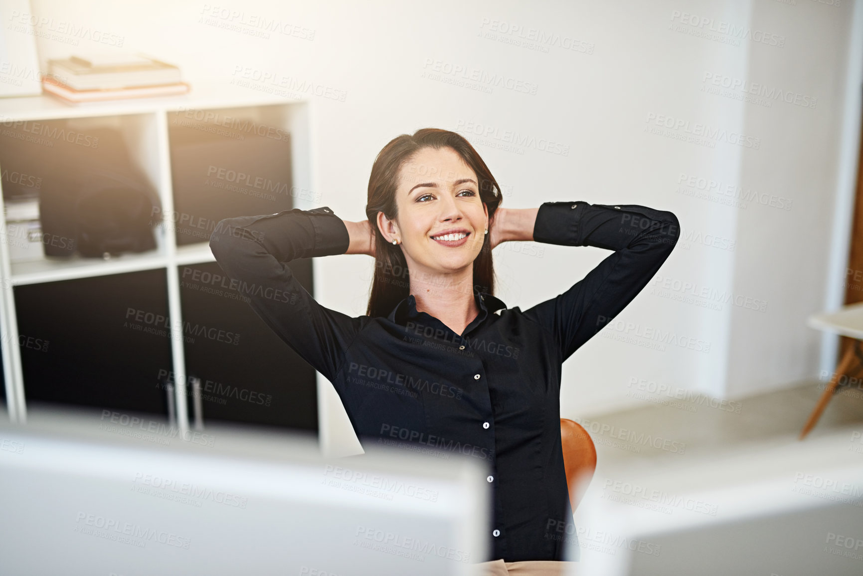 Buy stock photo Shot of a young businesswoman relaxing at her work desk