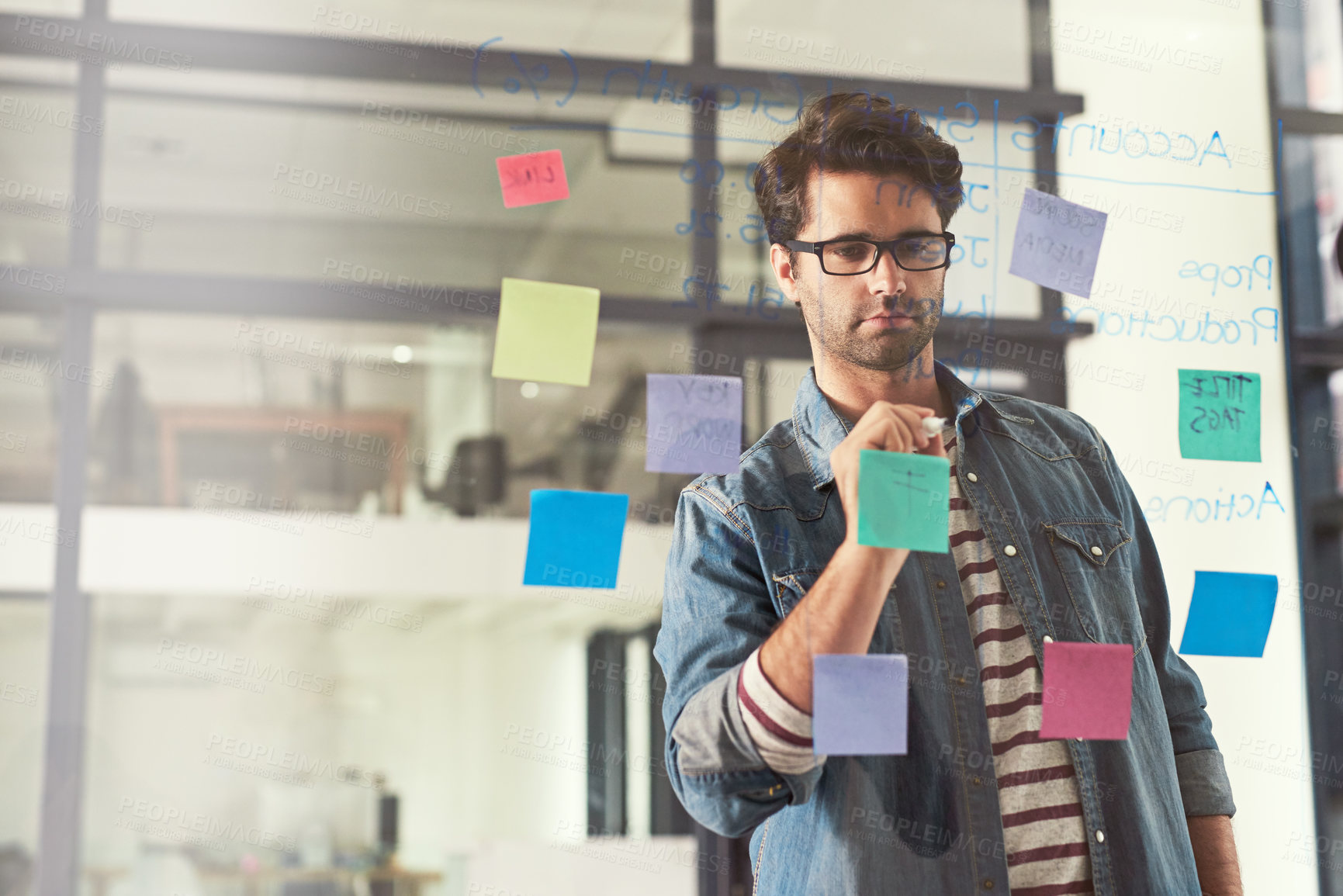 Buy stock photo Shot of a young designer playing around with ideas