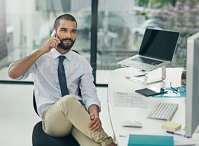 Buy stock photo Cropped shot of a young businessman using his cellphone while sitting in the office