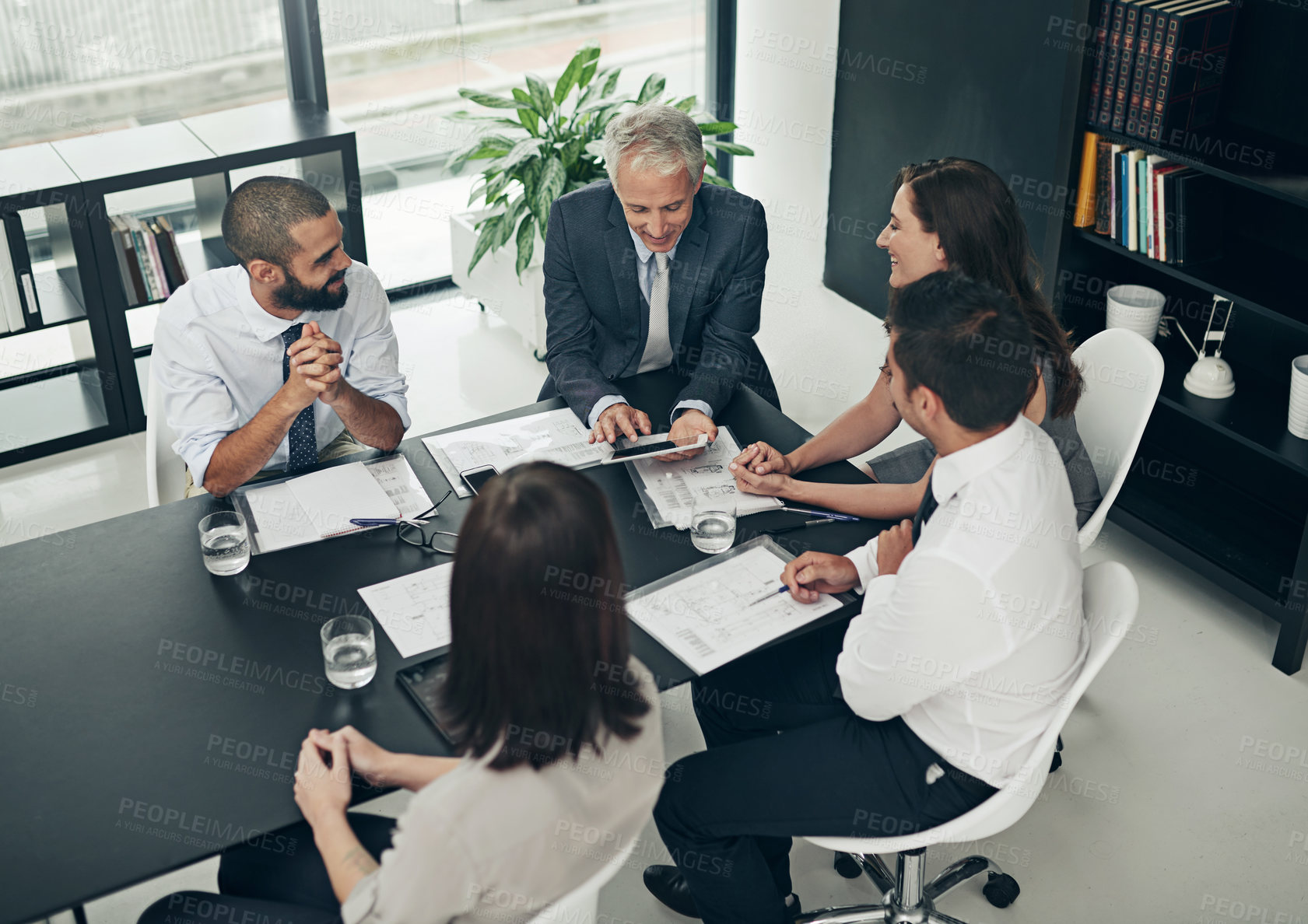 Buy stock photo High angle shot of a group of businesspeople meeting in the boardroom