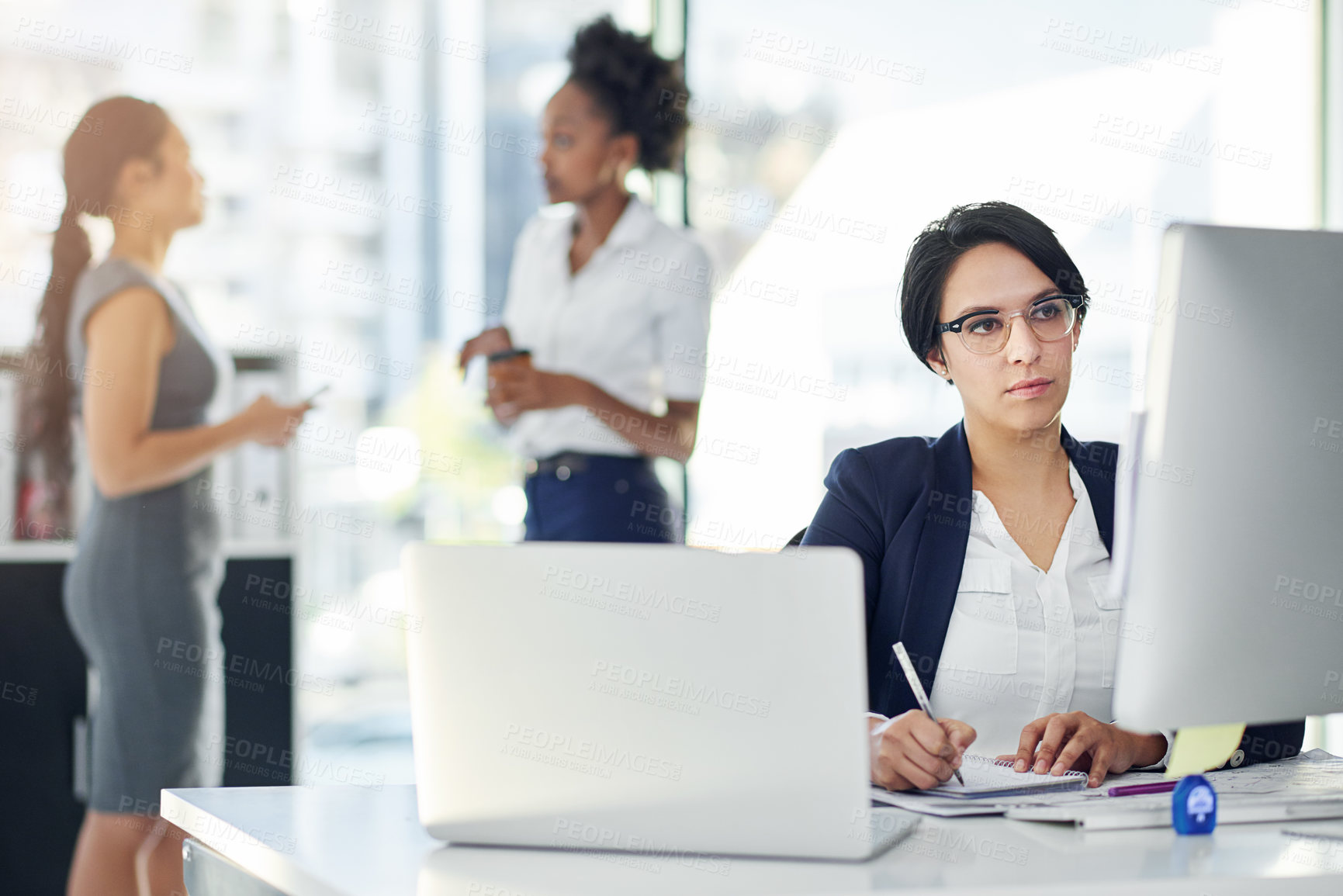 Buy stock photo Cropped shot of a businesswoman working in her office with colleagues in the background