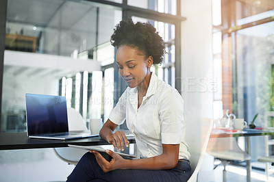 Buy stock photo Cropped shot of a young businesswoman working on a digital tablet in a modern office