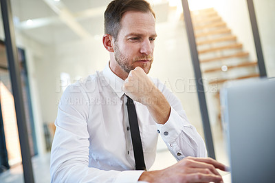 Buy stock photo Cropped shot of a businessman working on a laptop in a modern office