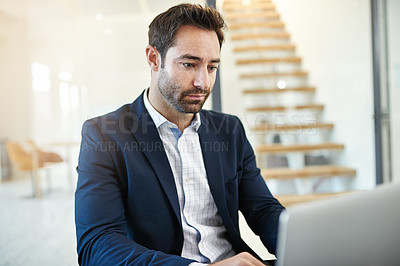 Buy stock photo Cropped shot of a businessman working on a laptop in a modern office