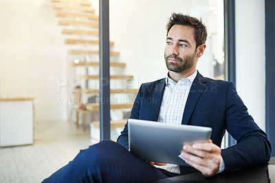 Buy stock photo Cropped shot of a businessman working on a digital tablet in a modern office