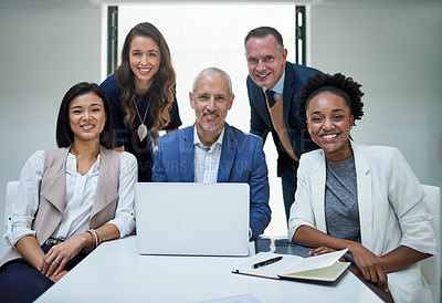 Buy stock photo Portrait, diversity and group of businesspeople by desk for collaboration, laptop and support. Global staff, smile and tech in modern office for cooperation with strategy meeting and sitting together