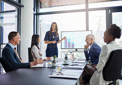 Buy stock photo Businesswoman analysis giving a statistic presentation in a diverse boardroom. Professional business female presenting to her work colleagues in the conference room, explaining graphics for growth.