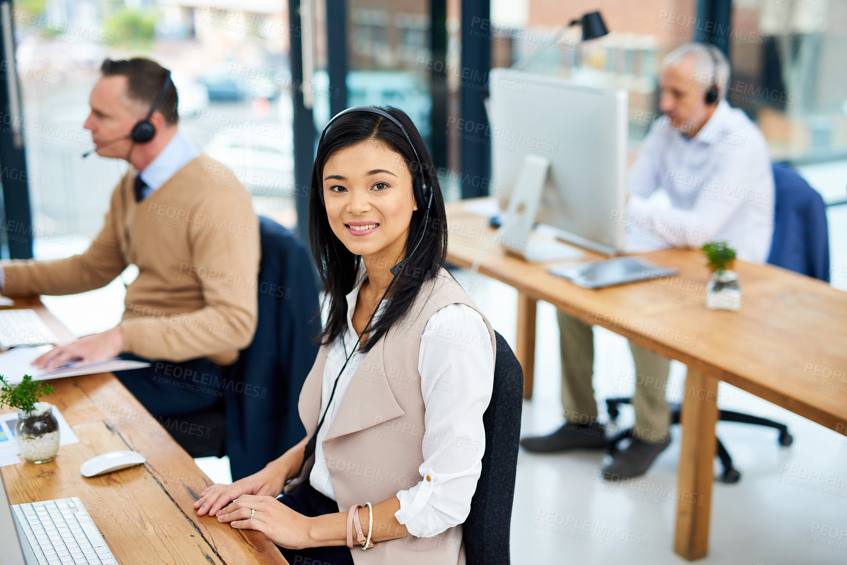 Buy stock photo Cropped portrait of a young businesswoman working in her office with colleagues in the background