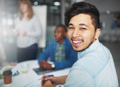 Buy stock photo Cropped portrait of a young businessman looking over his shoulder during a presentation in a boardroom