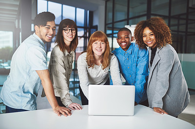 Buy stock photo Cropped portrait of a group of young businesspeople huddled around a laptop in their office