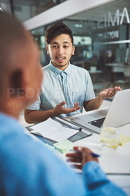Buy stock photo Cropped shot of a young businessman explaining something to his colleague in the boardroom