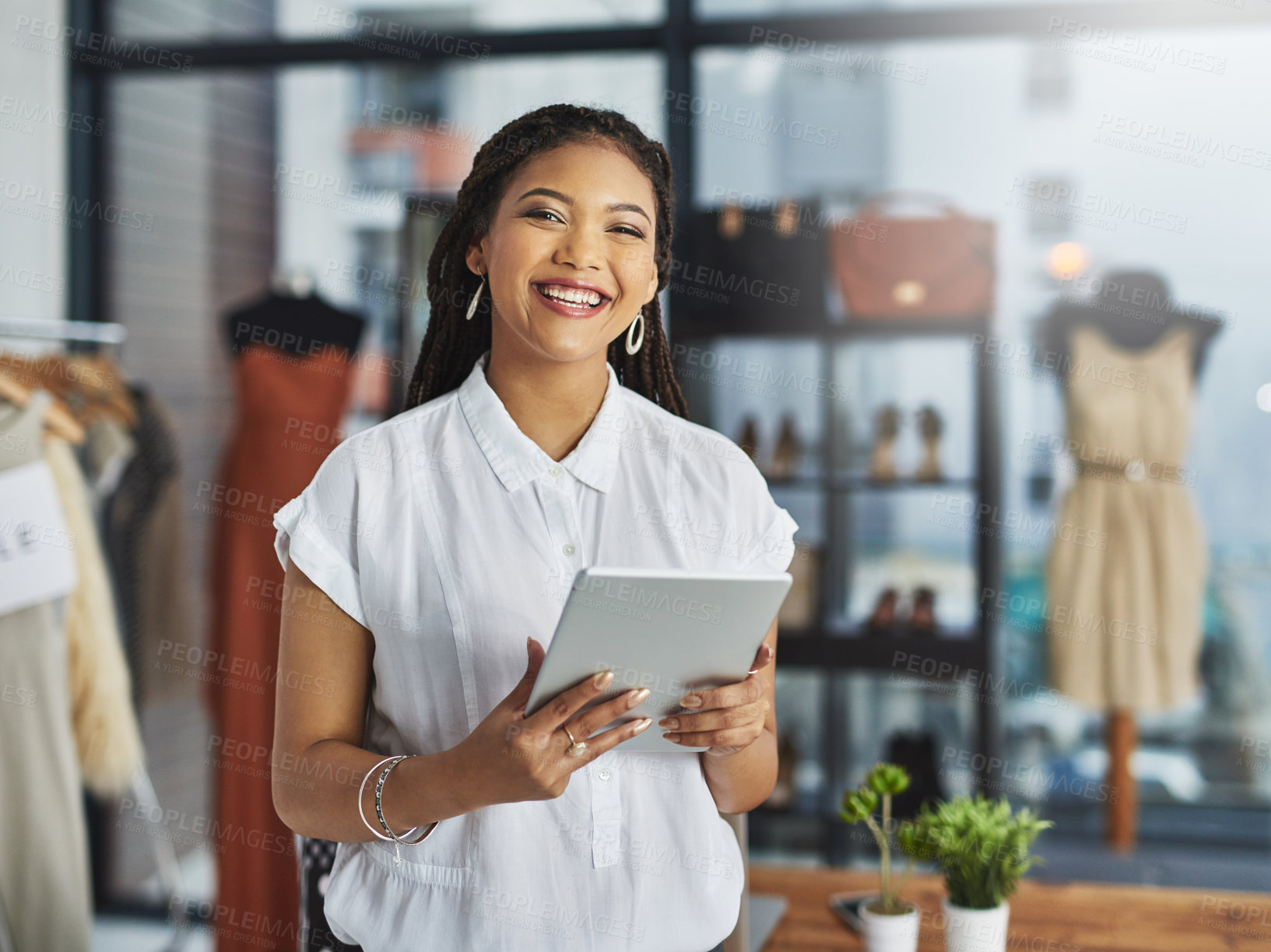 Buy stock photo Cropped portrait of a young business owner using her tablet while standing in her store