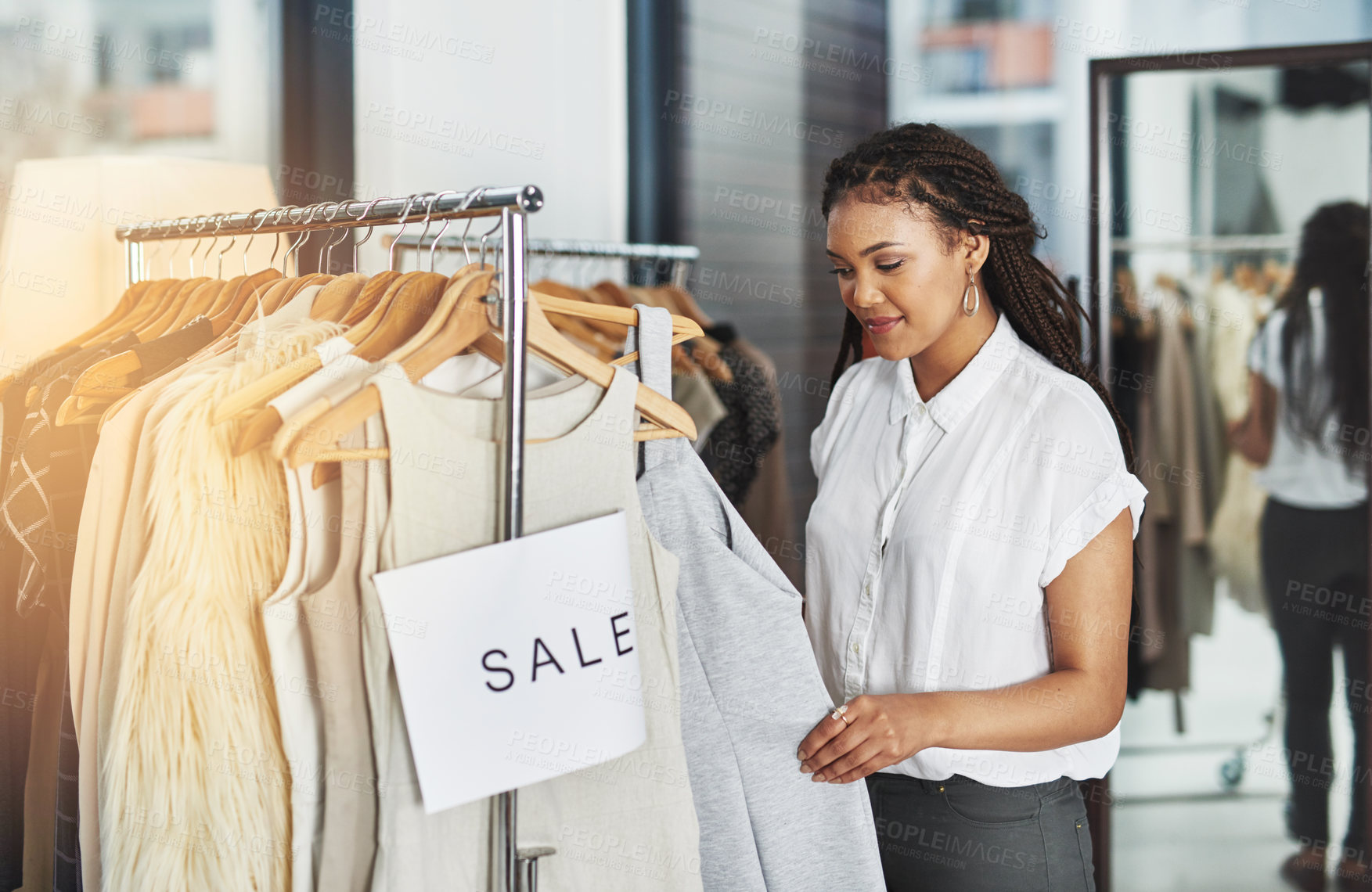 Buy stock photo Cropped shot of a woman looking at dresses on a rail with a sign that reads 