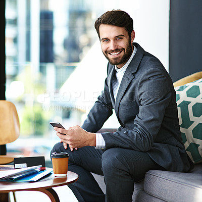 Buy stock photo Portrait of a young businessman texting on a cellphone in a modern office