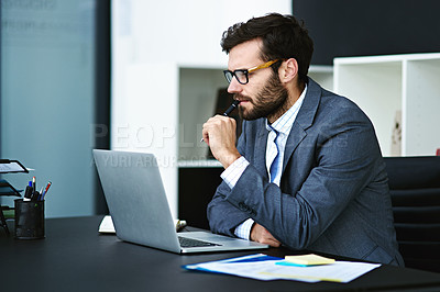 Buy stock photo Cropped shot of a young businessman working on a laptop in a modern office