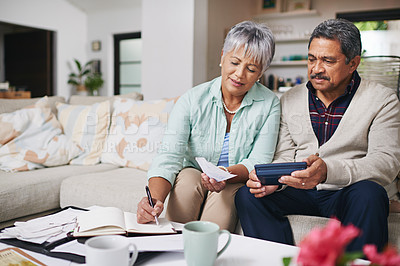 Buy stock photo Shot of an elderly couple working out a budget while sitting on the living room sofa