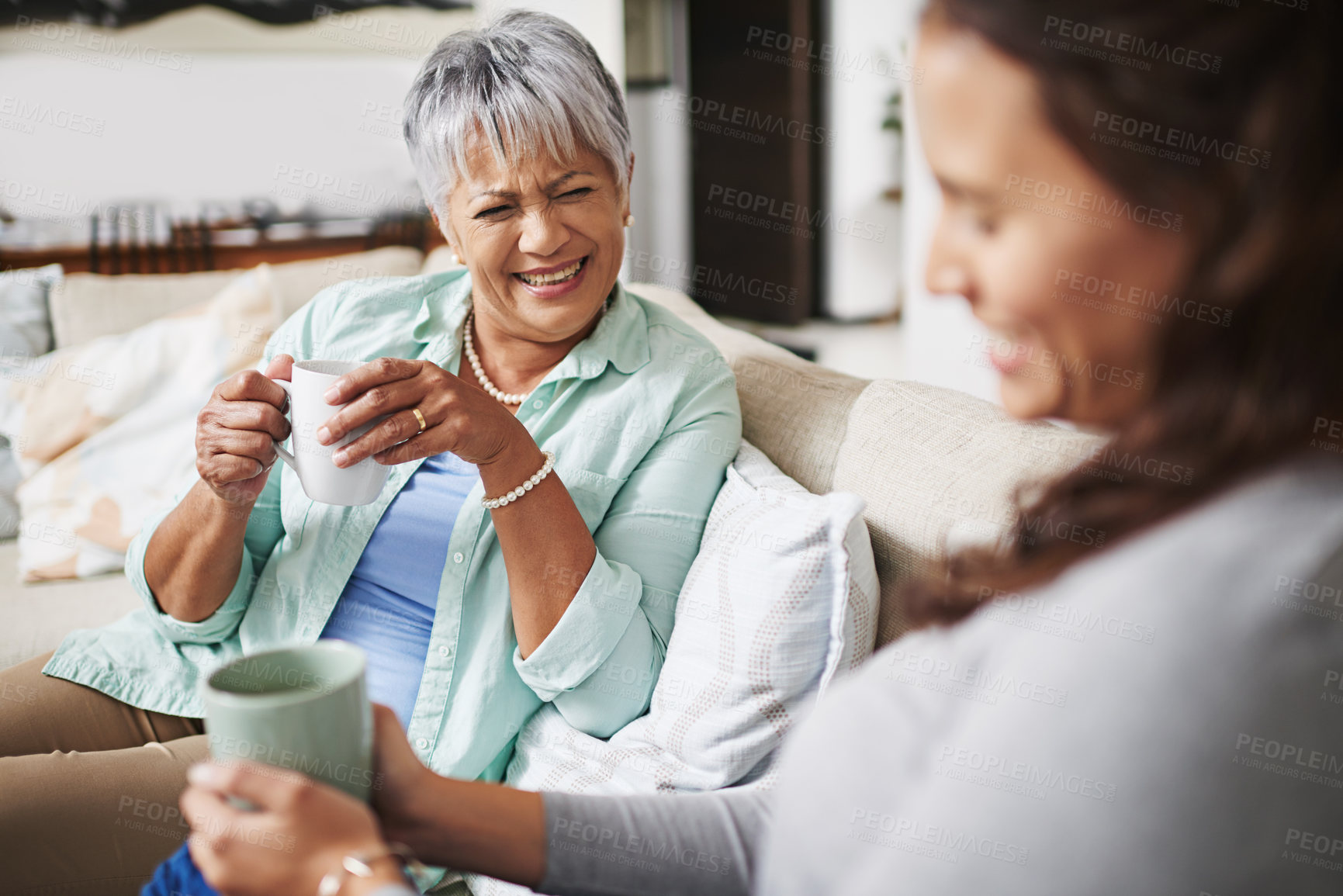 Buy stock photo Laugh, coffee and mother with daughter on sofa in living room for bonding, conversation and happiness. Smile, chat and discussion with women talking in family home for generations, reunion and break