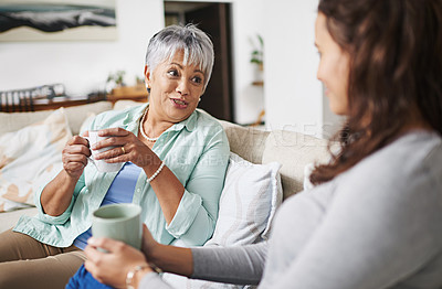 Buy stock photo Happy, coffee and mother with daughter on sofa in living room for bonding, conversation and happiness. Smile, chat and discussion with women talking in family home for generations, reunion and break
