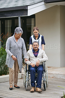 Buy stock photo Senior, man and portrait of support in nursing home with partner and nurse for person a disability in wheelchair. Retirement, help and people with kindness walking outdoor  and talk about healthcare