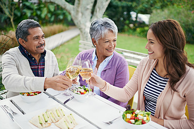 Buy stock photo Cropped shot of a family toasting over their lunch while sitting outside