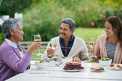 Buy stock photo Happy family and sitting with food or lunch together outdoors for celebration or birthday party in retirement. Woman and grandparents, toast with smile, wine or cheers for cake, talking and event