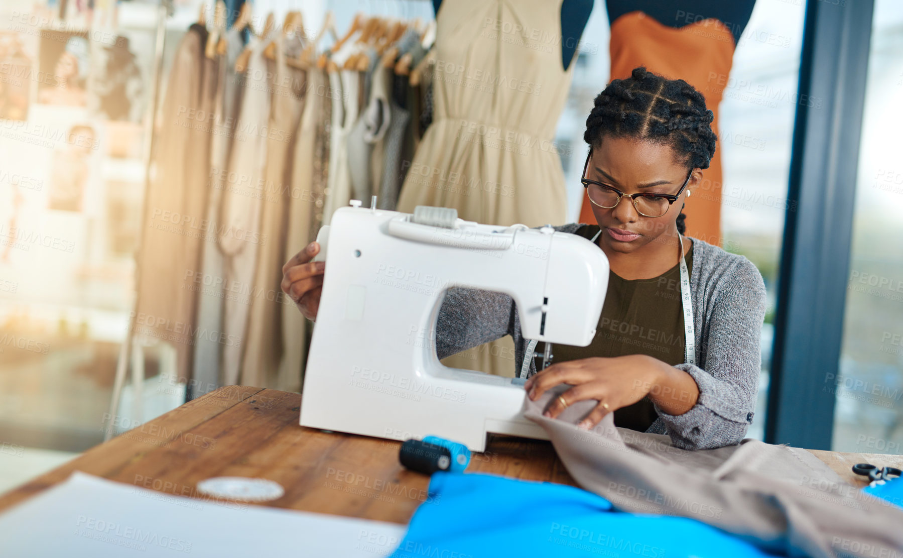 Buy stock photo Woman, fashion designer and sewing machine with fabric, production and process at small business. African person, needle and thread for clothes, garment and material with creativity in factory