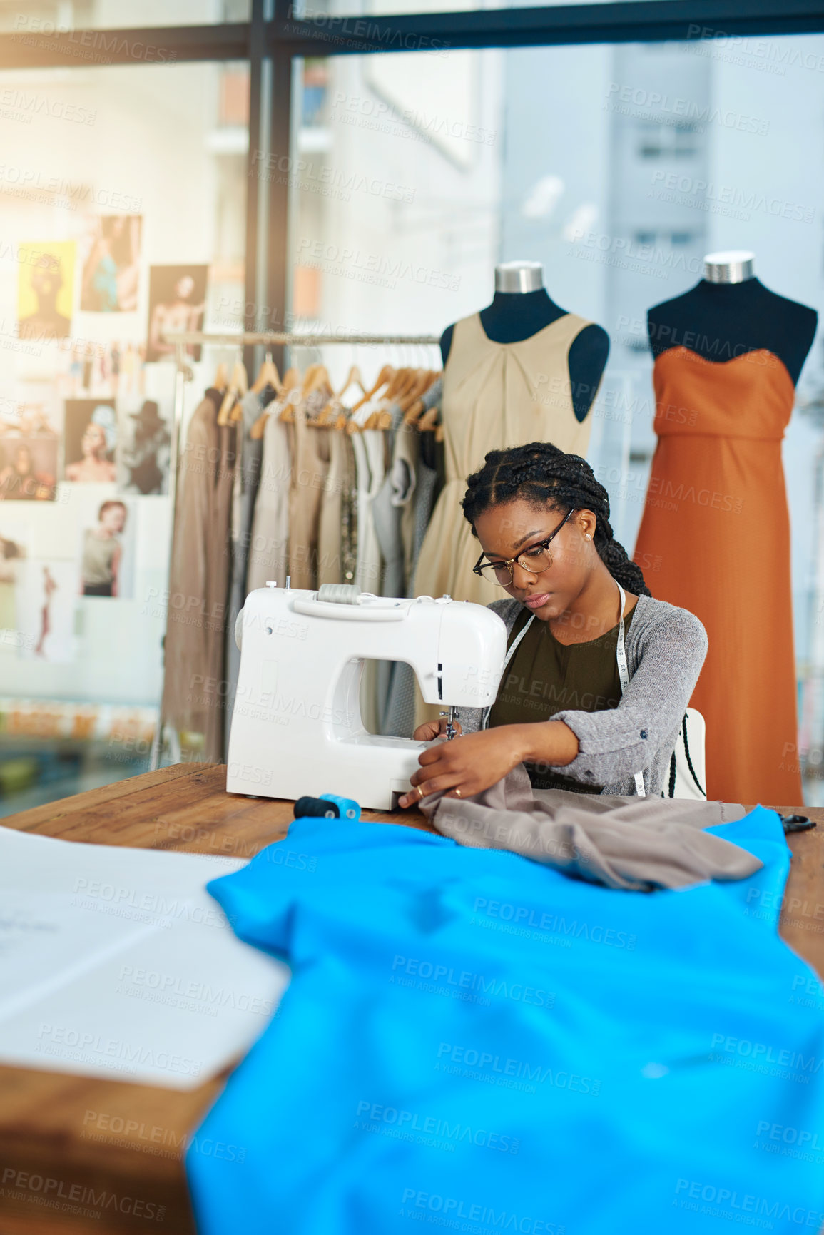 Buy stock photo Woman, fashion designer and sewing machine in workshop for clothes, production and process at small business. Person, tailor and blue cloth for garment, fabric and material with creativity in factory