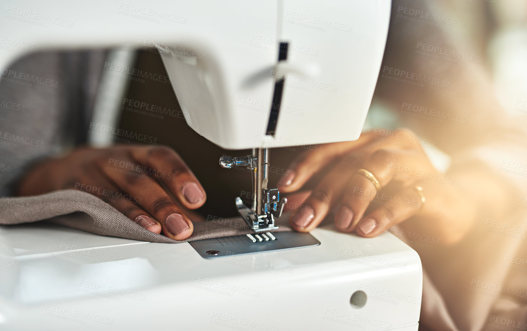 Buy stock photo Cropped shot of a young fashion designer using a sewing machine in her workshop