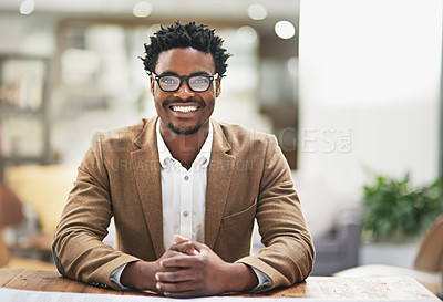 Buy stock photo Cropped portrait of a young businessman sitting at his desk in his office