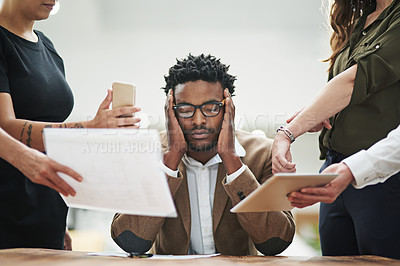 Buy stock photo Cropped shot of a young businessman feeling overwhelmed by his colleagues in the office