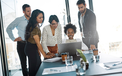 Buy stock photo Cropped shot of a group of businesspeople gathered around a laptop in the office