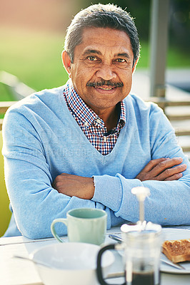 Buy stock photo Portrait of an older man having his breakfast outdoors