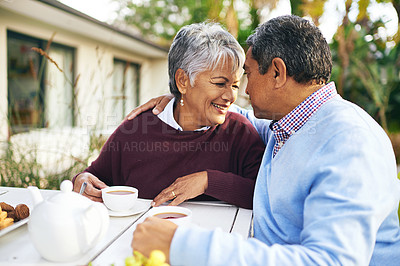 Buy stock photo Shot of a happy older couple having tea together outdoors