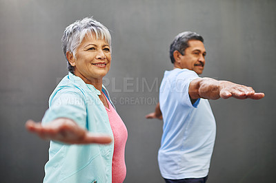 Buy stock photo Shot of a happy older couple practicing yoga together outdoors against a gray background