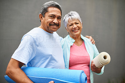 Buy stock photo Portrait of a happy older couple carrying their exercise mats outdoors
