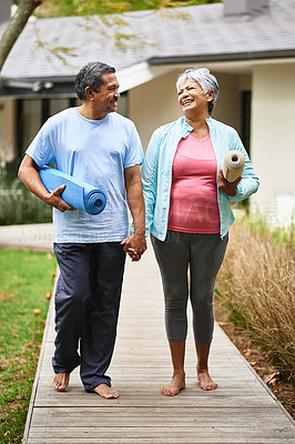 Buy stock photo Shot of a happy older couple carrying their exercise mats outdoors