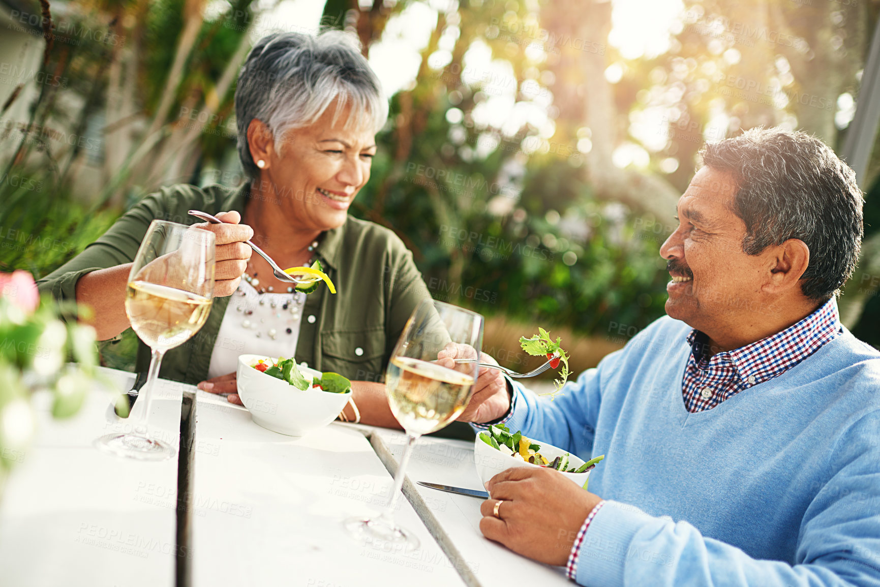 Buy stock photo Shot of a happy older couple enjoying a healthy lunch together outdoors