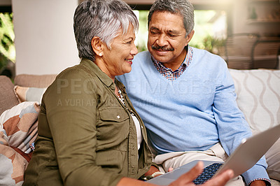 Buy stock photo Shot of a happy older couple relaxing on the sofa with a digital tablet at home
