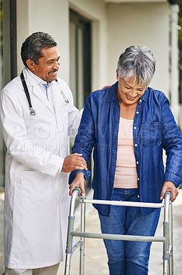 Buy stock photo Cropped shot of a male doctor going for a walk with his senior patient and her walker outside