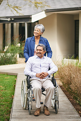 Buy stock photo Shot of a senior woman pushing her husband in a wheelchair outside