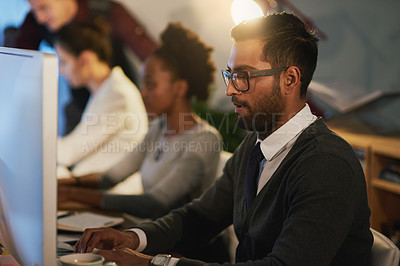 Buy stock photo Cropped shot of a young businessman and his colleagues working late at the office