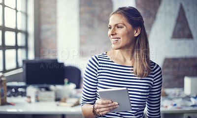Buy stock photo Shot of a young designer using her digital tablet in her office