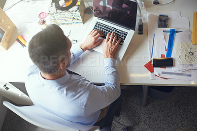 Buy stock photo High angle shot of a designer working on his laptop