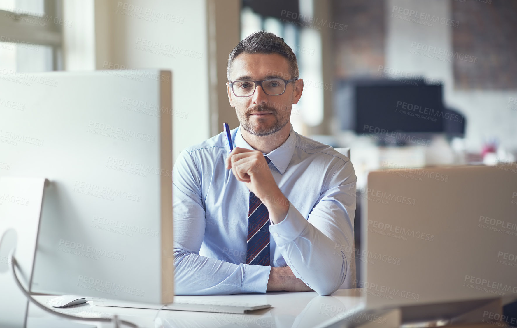 Buy stock photo Cropped shot of a businessman sitting by his computer in his office